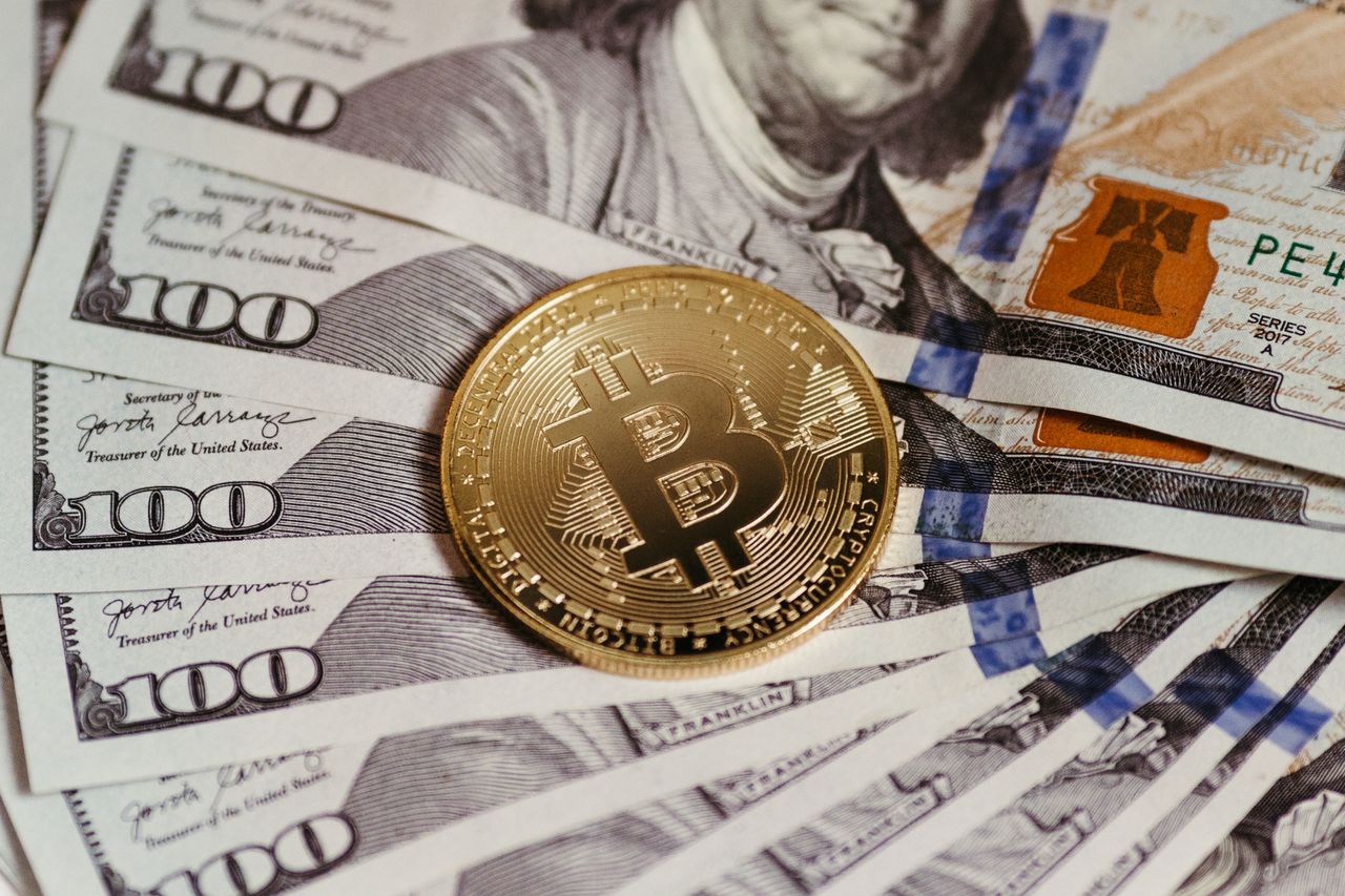 Services-02 Gold Bitcoin coin resting on US dollar bills showcasing digital and traditional currency.