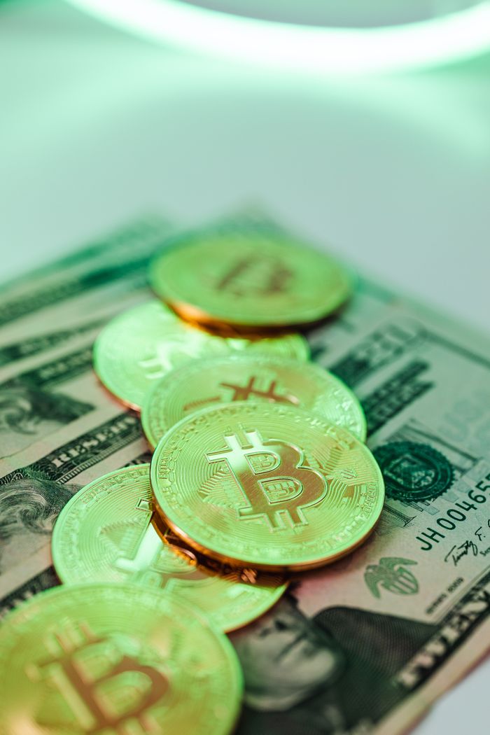 Crafting Captivating Headlines: Your awesome post title goes here Golden Bitcoin coins placed over American dollar banknotes, highlighting crypto and cash economy.