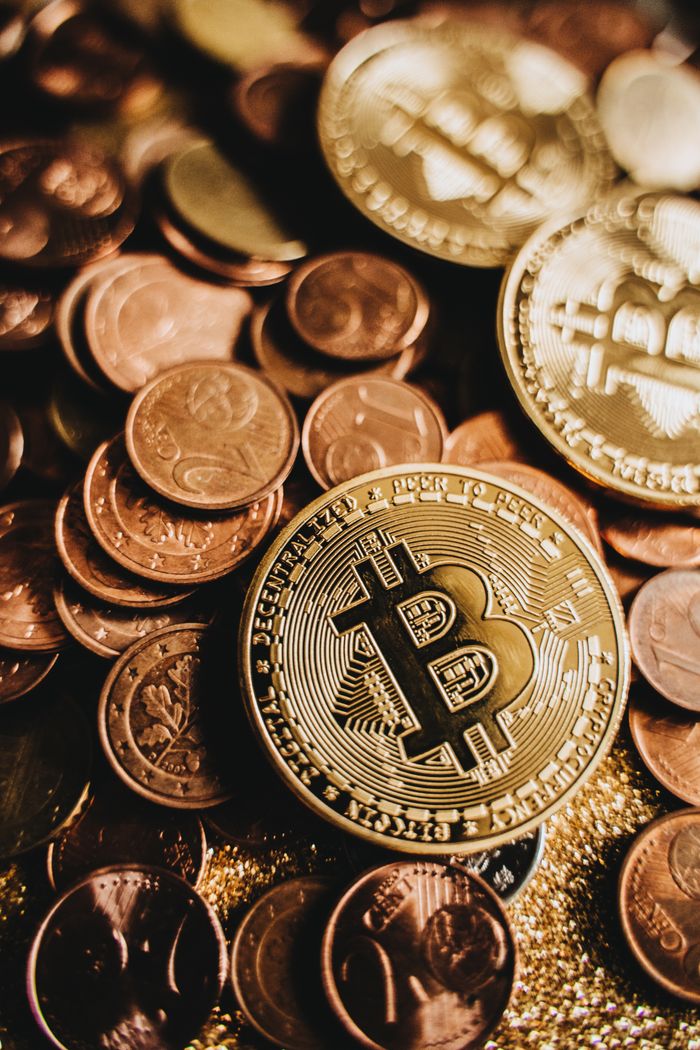 creative Close-up of shiny Bitcoin among assorted coins symbolizing wealth and digital currency.
