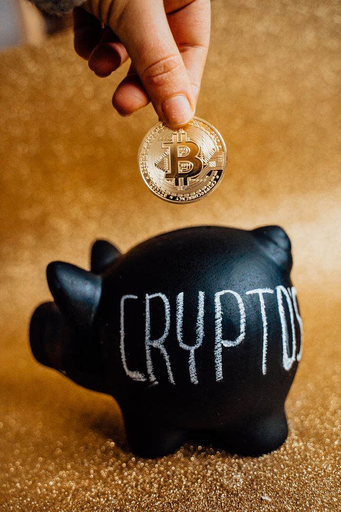 The Art of Drawing Readers In: Your attractive post title goes here A hand places a Bitcoin into a piggy bank labeled 'Crypto', symbolizing savings and investment.