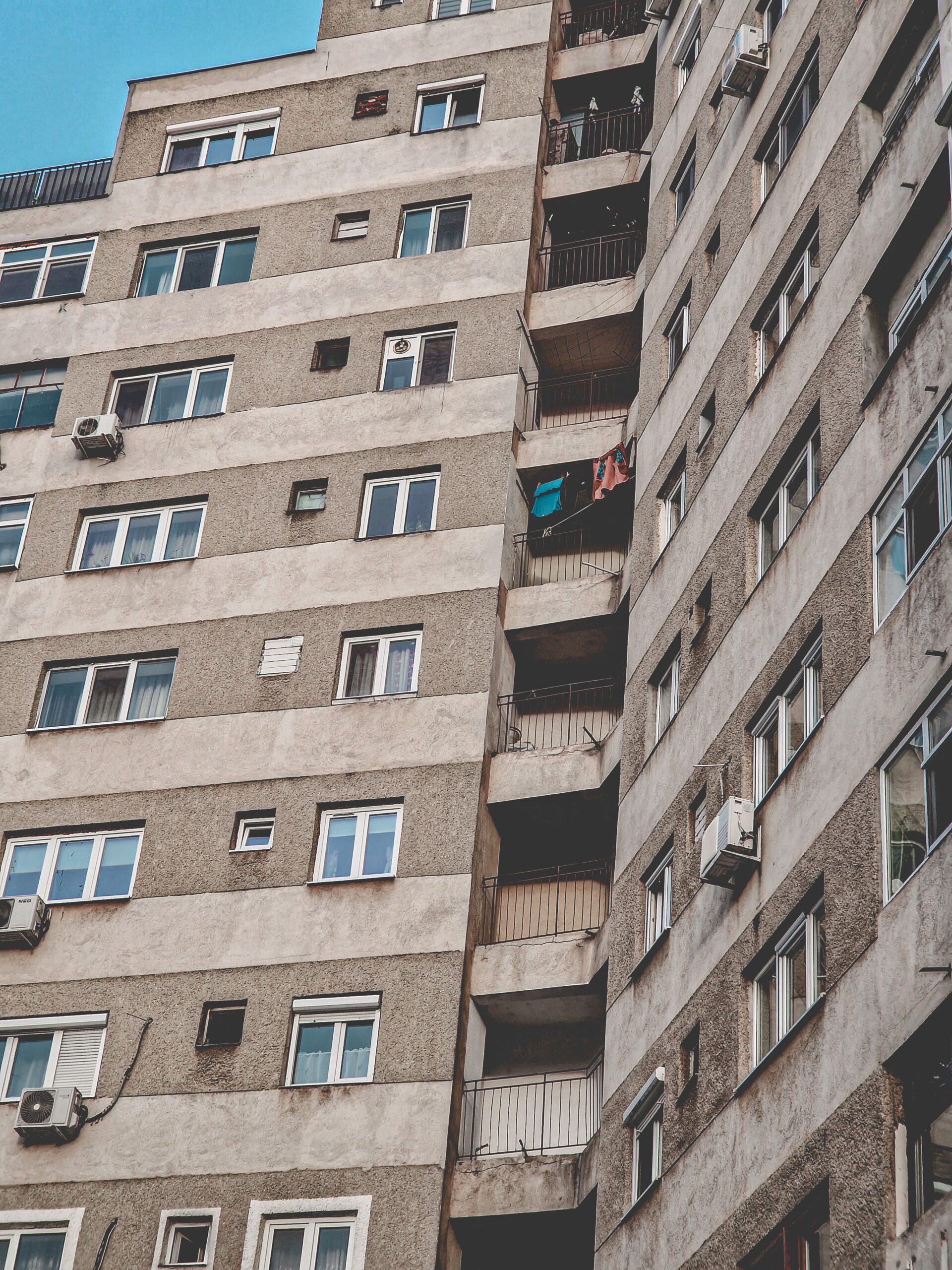 High-rise residential building with balconies and multiple windows in an urban setting.